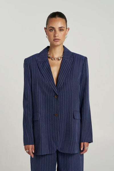 Front detail view of model wearing the Summi Summi OS Blazer in Navy Pinstripe, featuring structured shoulders, a relaxed fit, and dark tortoiseshell buttons.