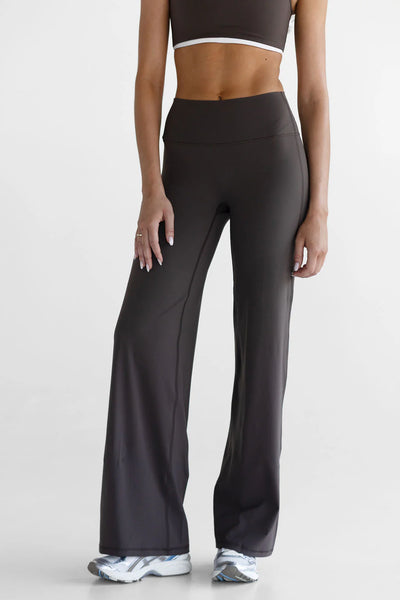 A mid-length front view studio shot focusing on the high-waisted fit of the LEELO Tall Sculpt Wide Leg Pants in dark chocolate. The framing highlights the secure, flattering flat-front waistband design that provides comfortable core coverage.