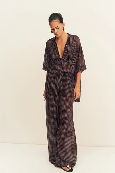 A full back view of the Maddox Drawstring Pant on a model, showcasing the clean hang of the fabric across the hips and the uniform distribution of the polka dot motif.