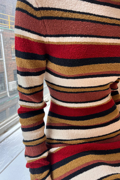 A close-up of the mid-weight bouclé knit fabric, highlighting the soft, textured loops and the earthy multi-tonal stripe design.