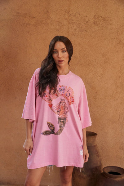 Front view of a model wearing Sabbi The Very Oversized Lucky Mermaid Tee in Bright Pink, showcasing the slouchy silhouette and playing card mermaid print.