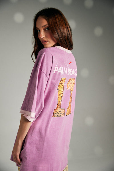 An expressive, full-length lifestyle image of a model posing dynamically on a concrete path, demonstrating how the very oversized cotton tee can be styled effortlessly for high-energy streetwear looks.