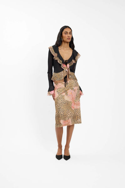 A full-length front view of the cardigan on a model, styled as a coordinated set with the matching leopard midi skirt to show the complete day-to-night lifestyle look.