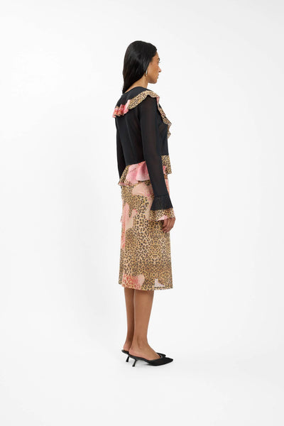 A full back view of the model wearing the matching set, highlighting the sheer back paneling of the leopard cardigan and the subtle black ruffle accent resting at the base of the neck.