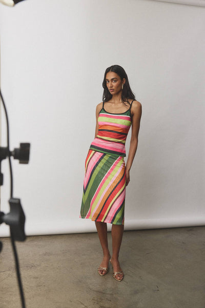 A full-length front studio shot of a model showcasing the With Harper Lu Midi Skirt in Emerald Stripe, highlighting the form-fitting mid-waist tailoring and the subtle A-line flare at the hem.