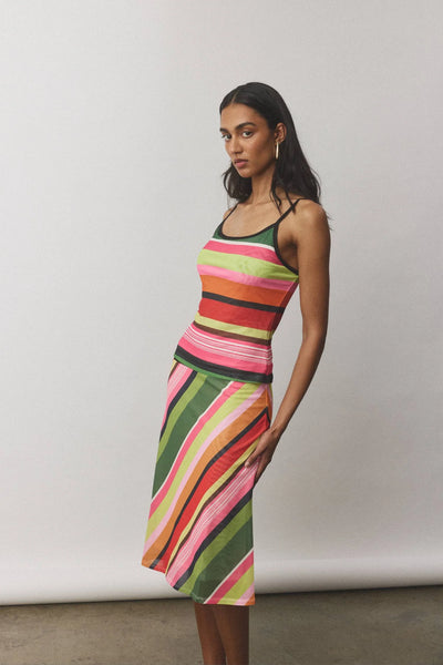 A full-length front studio shot of the Emerald Stripe camisole styled as a matching set with the coordinating mesh midi skirt, showcasing a complete daytime-to-evening holiday look.