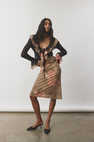 A clean, isolated studio image presenting the frill cardigan from the front on a model, showcasing how the two center front ties secure the lightweight sheer fabric.