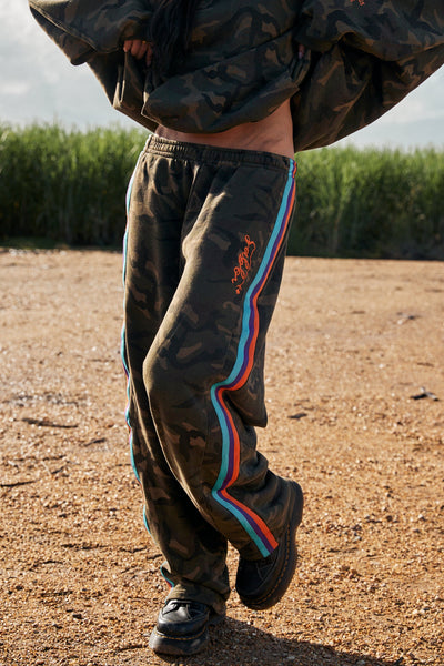 A detailed side shot focusing on the pop of color from the contrast stripe against the muted tones of the enzyme-washed camo print.