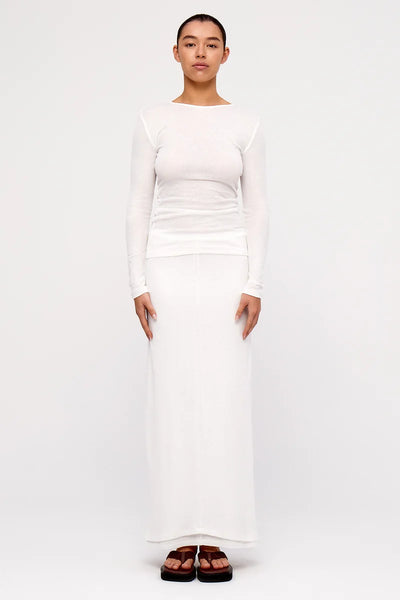 Full-length front view of a model wearing the white Zulu & Zephyr Rib Hemp Jersey Long Sleeve Top styled with a matching white maxi skirt.