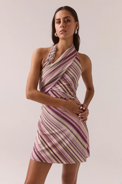 Front half-length shot of a model wearing the Vere Myriad Sarina halter mini dress in orchid featuring a gathered crossover neckline and textured diagonal striped mesh fabric.