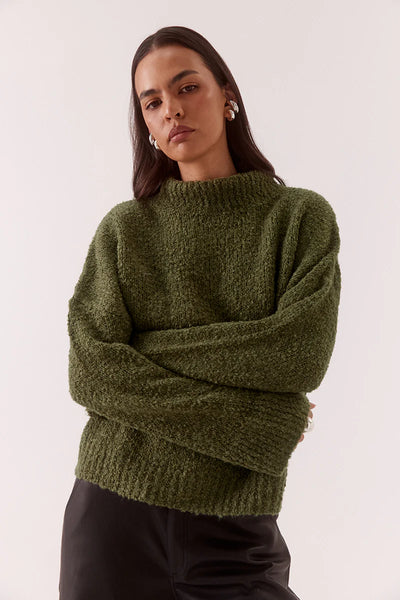 A three-quarter side profile view of the fully fashioned knit sweater, demonstrating the generous drape of the sleeves and the relaxed fit through the body.