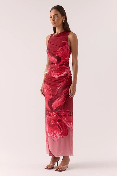 Full-length front view of a model standing in the Vere Florence raspberry midi dress with a twist front, side gathers, and a bold floral graphic motif.