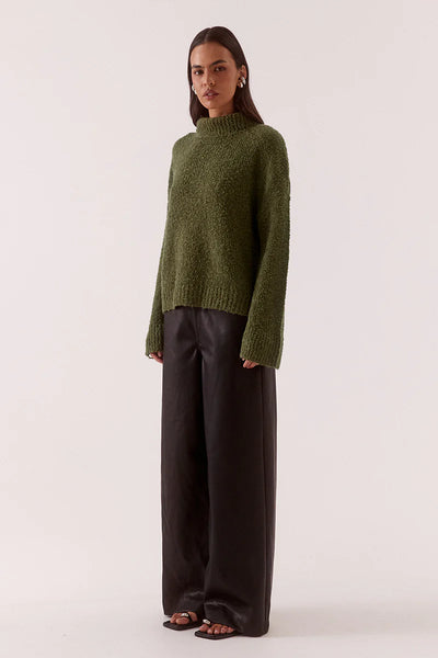 A three-quarter side profile view of the fully fashioned knit sweater, demonstrating the generous drape of the sleeves and the relaxed fit through the body.
