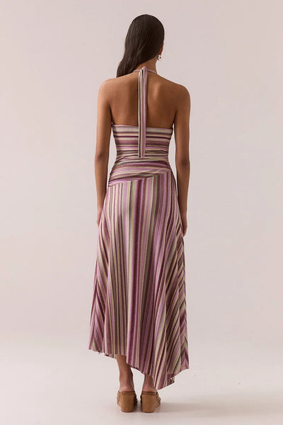 Full-length back view of a model wearing the Vere Sarina halter neck maxi dress in orchid featuring an open back, halter tie detail, and flowy striped skirt.
