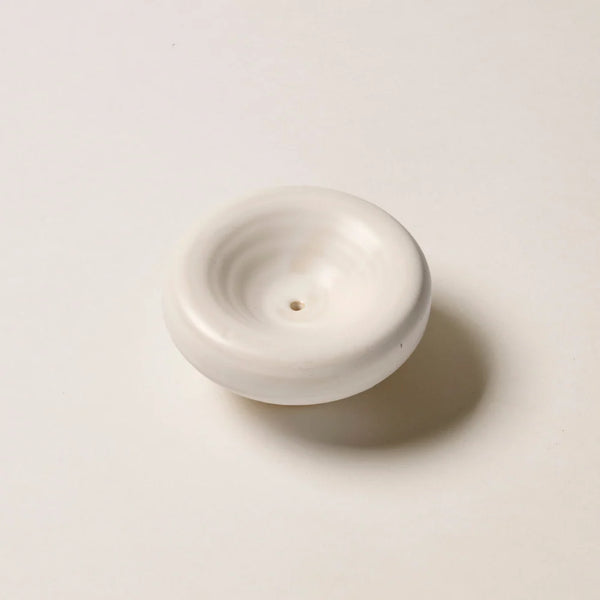 High-angle studio product shot of the Gentle Habits Vessel Incense Holder in Cream, showcasing its smooth circular form and soft matte cream glaze.