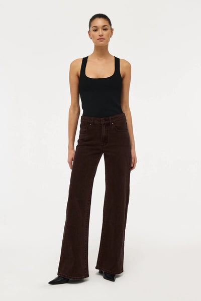 Front full-length view of a model styling Neuw Eva Wide jeans in Sable, showing the mid-rise waist, fitted hip section, and full-length wide leg.
