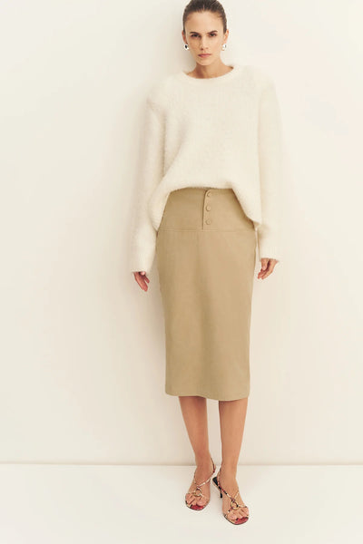 Front full-length view of a model posing in the snow white Shona Joy Korine fluffy textured wool blend sweater styled with a sand high-waisted midi skirt.