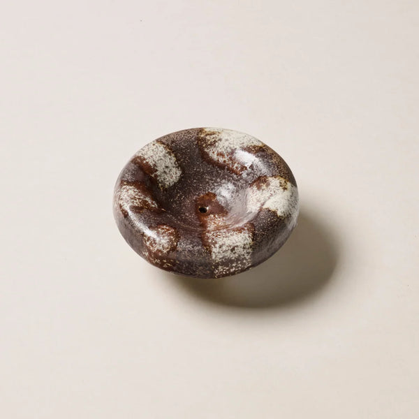 Overhead studio view of the Gentle Habits Vessel Incense Holder in Chocolate showing its rounded ceramic dish shape with a chocolate brown and cream striped glaze.