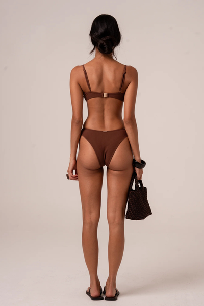 A full back view of the Choc Rib swim briefs on a model, highlighting the flattering medium-to-cheeky rear coverage and secure, flat-locked stitched seams.