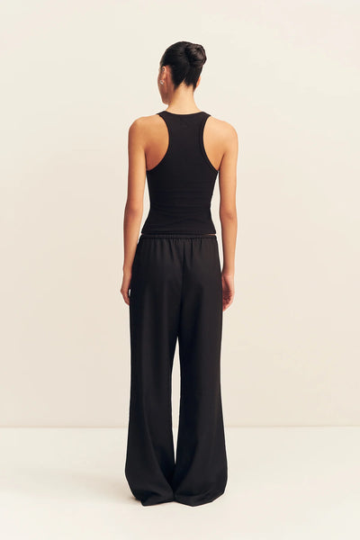 Back view of a model wearing the black mid-rise Shona Joy Castro suiting trousers paired with a fitted black racerback tank top.