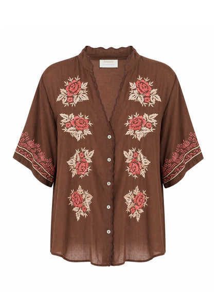 Studio e-commerce product display of the Auguste The Label Rosalie Blouse in Cocoa against a clean white background. This front view showcases the rich brown cotton voile fabric, a scalloped V-neckline and button placket, elbow-length sleeves, and the intricate red, pink, and cream hand-embroidered floral motifs down the front and along the sleeve cuffs.