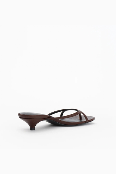 Rear three-quarter studio angle of the chocolate brown mule, displaying the clean backless silhouette and heel height.
