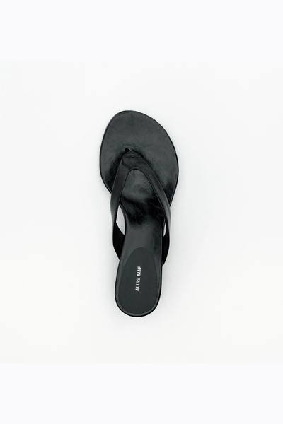 Rear three-quarter view of the slip-on sandal, displaying the clean lines and profile of the sculpted wedge heel.