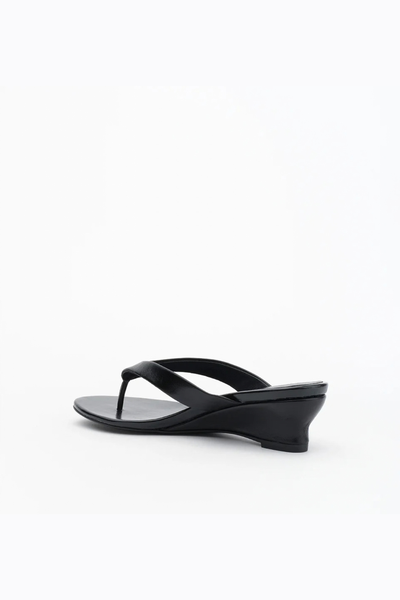 Rear three-quarter view of the slip-on sandal, displaying the clean lines and profile of the sculpted wedge heel.