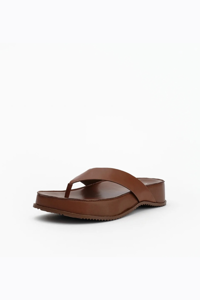 Front three-quarter view of the cocoa brown leather thong sandal, highlighting the wide supportive strap and the 40mm chunky flatform sole.