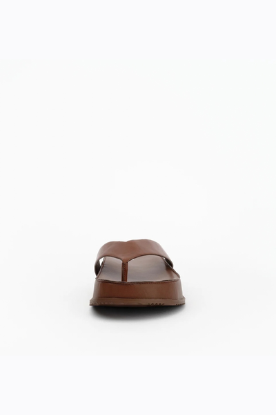 Direct front-facing view of the cocoa leather sandal, focusing on the toe post and the structure of the chunky platform sole.