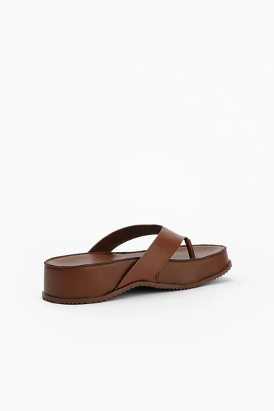 Rear three-quarter view of the slip-on sandal, displaying the clean lines, heel profile, and textured rubber outsole.