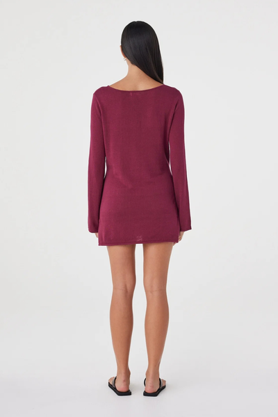 Full-length studio back view of a model wearing the long-sleeve merlot Arcaa Movement Kira Mini Dress with a straight hemline and wide boat neck.