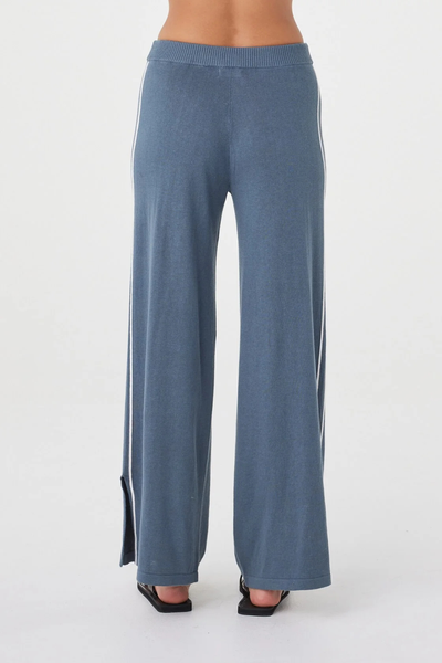 Cropped studio back shot of the storm blue Arcaa Movement Pippa Pant 2.0, displaying the ribbed elastic waist and wide-leg hem with side splits.