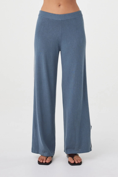 Cropped studio front shot of the storm blue Arcaa Movement Pippa Pant 2.0, highlighting the fine ribbed waistband and fluid wide-leg silhouette.