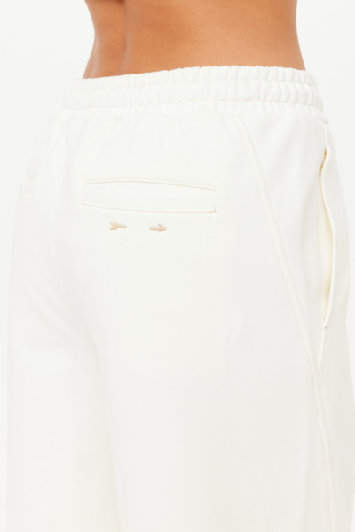 A close-up of the rear welt pocket featuring contrast mocha stitching and the signature embroidered arrow logo.