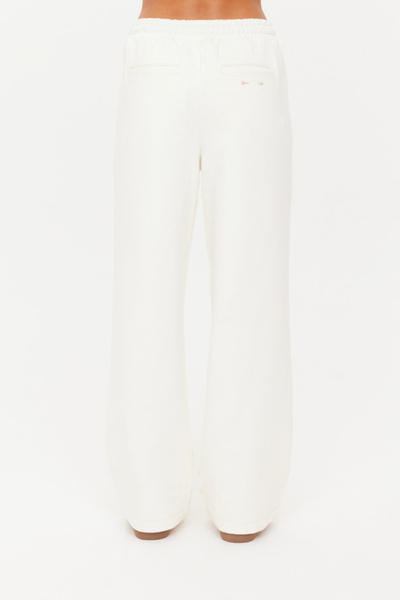 A full back view of the cream barrel pants, showcasing the relaxed fit and the placement of the back welt pockets.
