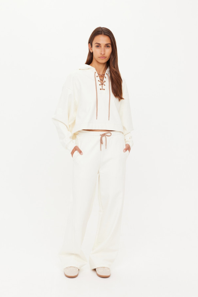 A front studio shot of the relaxed Arkana Priah Hoodie in cream, highlighting the boxy fit and the distinctive lace-up front detail.