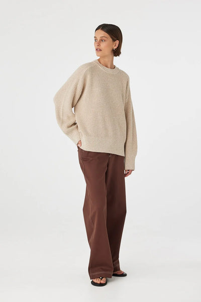 ear view of the Solene Sweater, showcasing the expansive mottled knit pattern and the seamless flow of the raglan shoulders across the back.