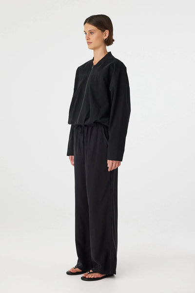 Rear view of the black Wren Bomber, showcasing the expansive, clean back panel and the structured drape of the wadded cotton fabric.