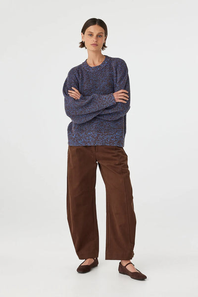 A detailed mid-length close-up shot focusing on the neckline, highlighting the seamless raglan sleeve construction, thick ribbed collar trim, and the heavy-gauge tactile texture of the chunky cotton yarn.