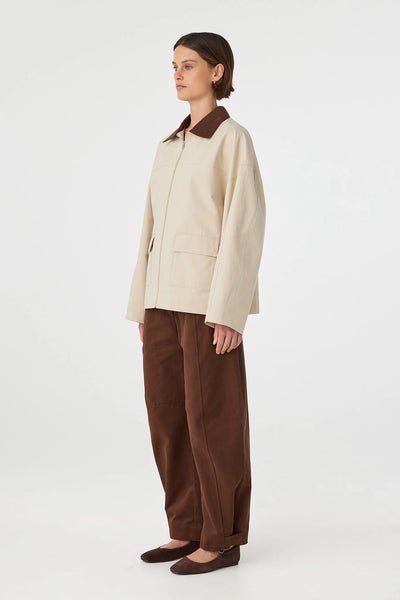A clean front-angle e-commerce image focusing on the jacket bodice, detailing the symmetrical front flap pockets and structured drape of the heavyweight cotton fabrication.