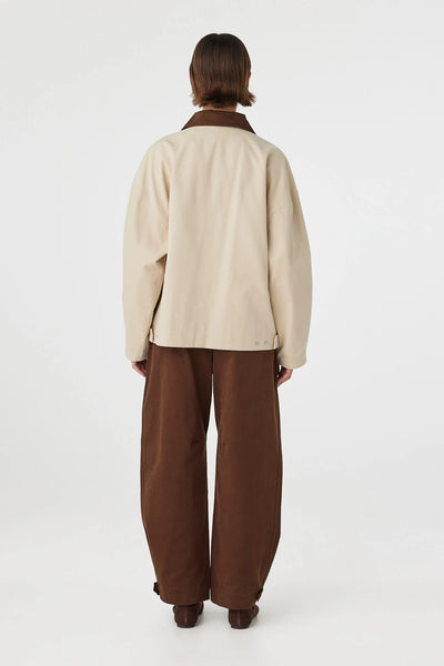 A direct full-length back view demonstrating the clean shoulder panel line and the boxy cut that drops neatly across the lower waistline.