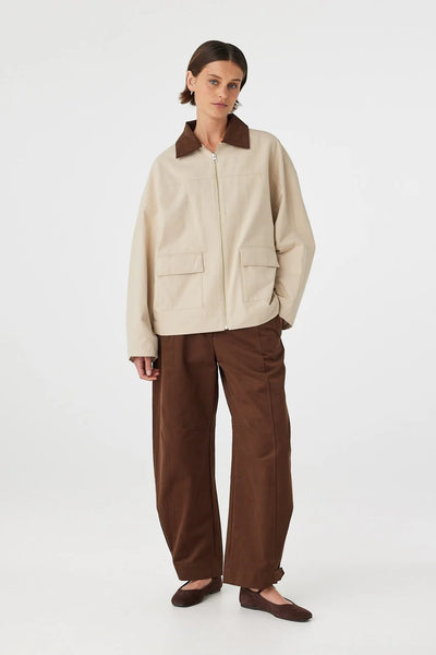 A three-quarter studio profile view of the utility jacket on a model, highlighting the straight-cut sleeve hang and loose, easy-layering fit.