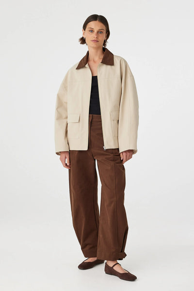 A dynamic, slightly angled lookbook frame showcasing the natural structure and relaxed utility appeal of the velvet-finish cotton jacket during movement.