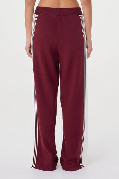 A detailed close-up shot from behind focusing on the upper waist of the Emery Pant. It showcases the secure fit of the ribbed merlot waistband and the clean finish of the knit fabric across the hips.
