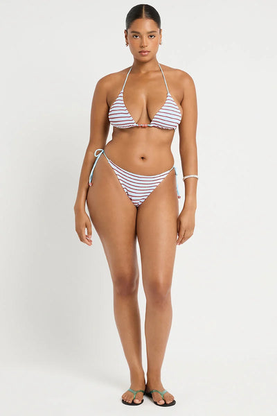 Studio front view of a curve model wearing a light blue and red micro-striped sliding triangle halter bikini top with beaded details and matching tie-side briefs.