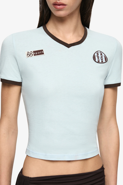 Close-up view highlighting the "BB Sport" and crest embroidered patches on the sky blue cotton jersey fabric.