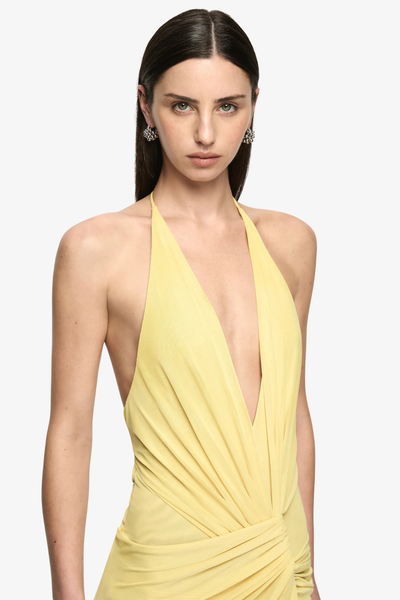 Upper body studio portrait of a model wearing a citron yellow soft mesh halter maxi dress featuring a plunging V-neckline and dynamic twist-draped waist details.