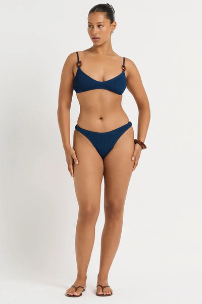 Full-length front view of model Yaz wearing the Bond-Eye Ring Edwards Crop bikini top in Marine Recycled with scoop neckline and matching bottoms.