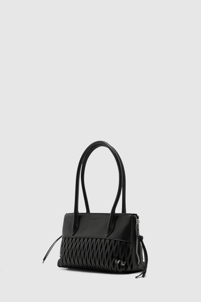 Three-quarter angle studio shot of the black Brie Leon Faye Mini Tote in recycled leather, displaying the laser-cut diamond detailing, unzipped side gussets with long leather ties, and silver hardware.
